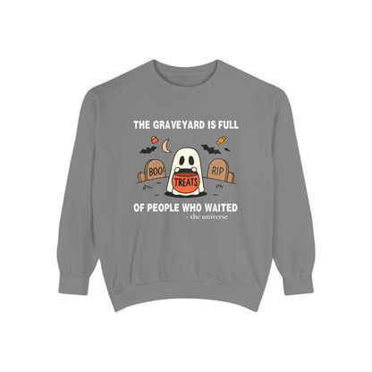 Sweatshirt with a ghost in a graveyard holding treats and Halloween text.