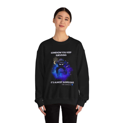 Black sweatshirt with a cosmic graphic and text that reads "Somehow you keep surviving. It's almost suspicious - the universe."
