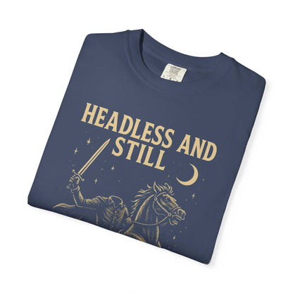Folded navy blue Headless Horseman shirt with beige spooky horseman graphic and "Headless and Still" text, eco-friendly cotton motivational Halloween tee.