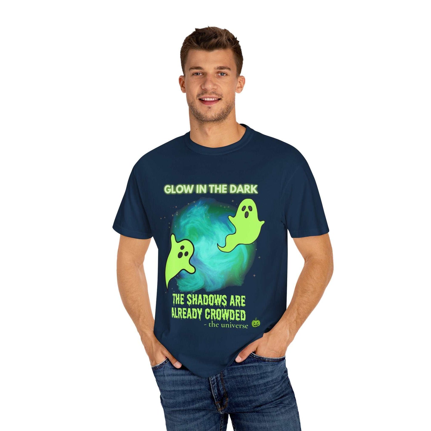A man wears a navy t-shirt with a glow-in-the-dark ghost design and text.