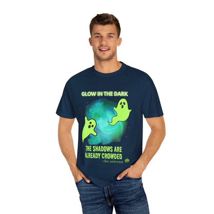A man wears a navy t-shirt with a glow-in-the-dark ghost design and text.