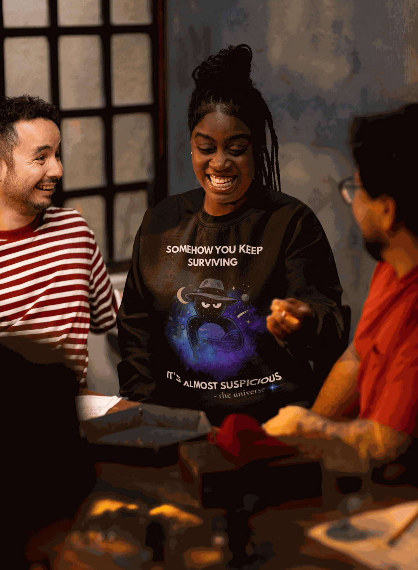 A black sweatshirt with a cosmic graphic and the text "Somehow You Keep Surviving It's Almost Suspicious".