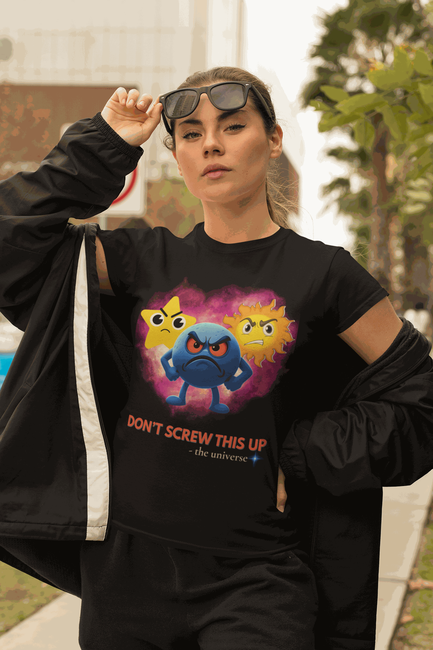 A black t-shirt with a graphic of three angry celestial emojis and the text "DON'T SCREW THIS UP".
