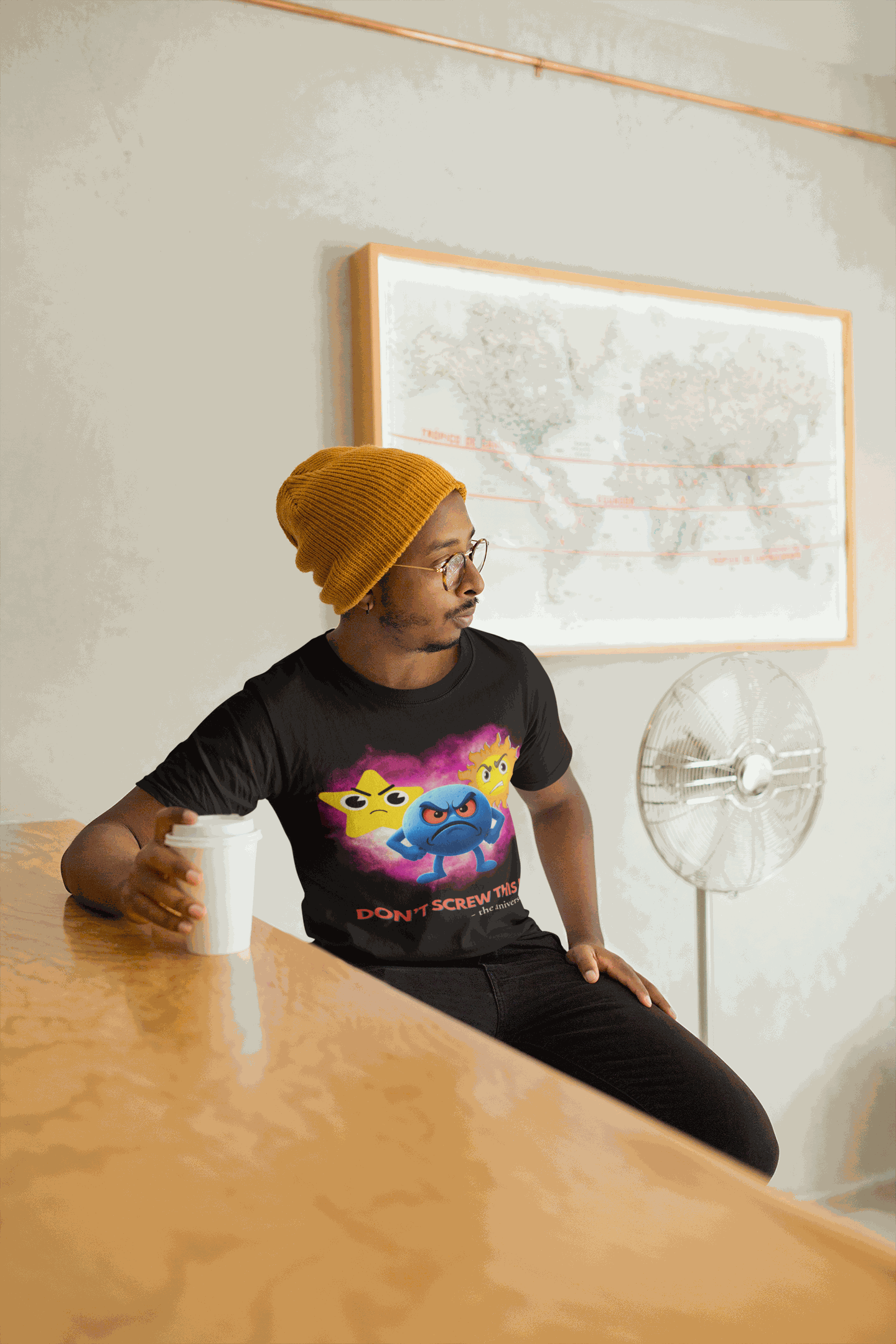 A man wears a black t-shirt with a graphic of three angry cartoon characters.