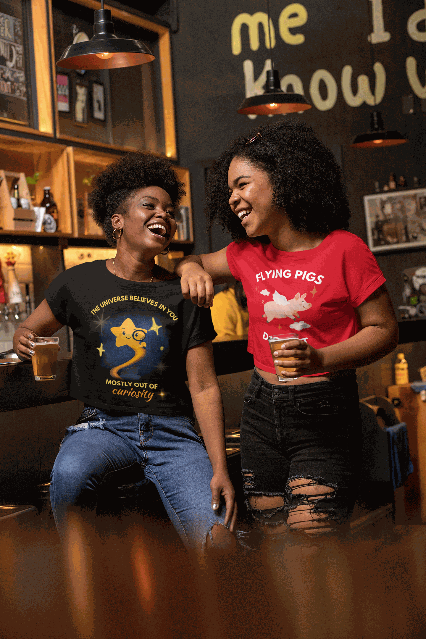 A black t-shirt with a graphic of a curious star and the text "The Universe Believes in You".