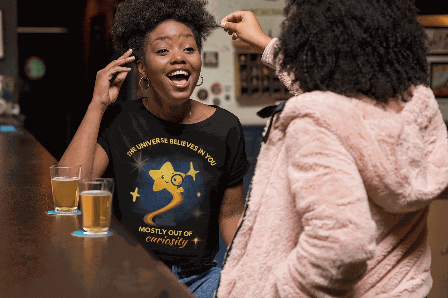 A black t-shirt with a graphic of a curious star and text.