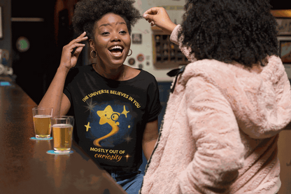 A black t-shirt with a graphic of a curious star and text.