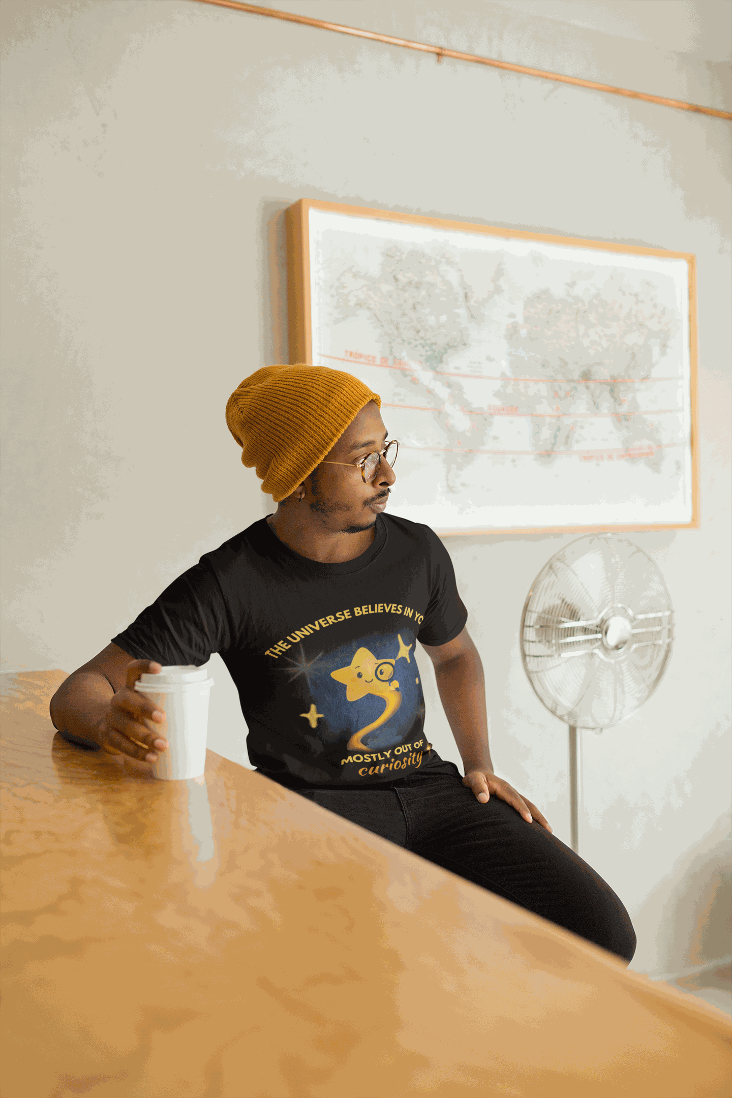 A man wears a black t-shirt with a graphic of a star and text.