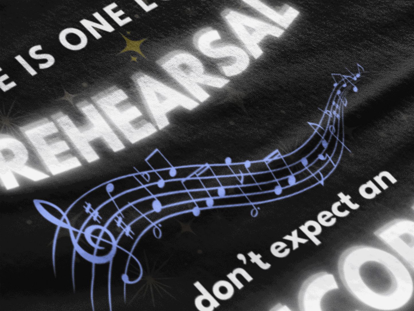 Black t-shirt with white text "Life Is One Long Rehearsal" and musical notes.