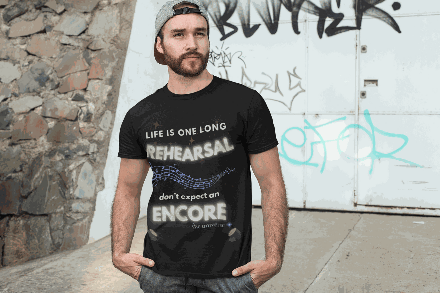 A man wears a black t-shirt with the text "Life Is One Long Rehearsal, Don't Expect an Encore" and musical notes.