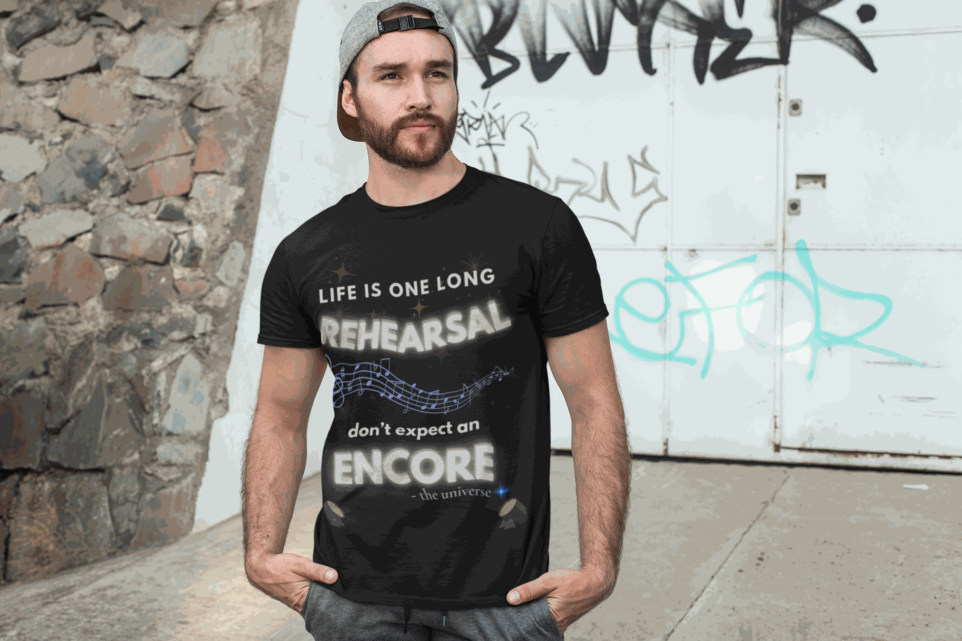 A man wears a black t-shirt with the text "Life Is One Long Rehearsal, Don't Expect an Encore" and musical notes.