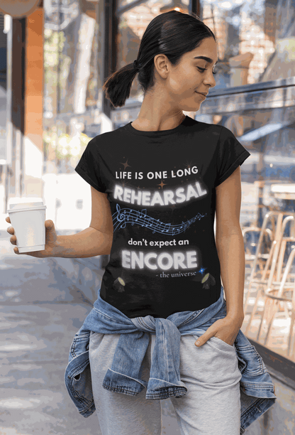 A woman wears a black t-shirt with the text "Life Is One Long Rehearsal, Don't Expect an Encore" and musical notes.