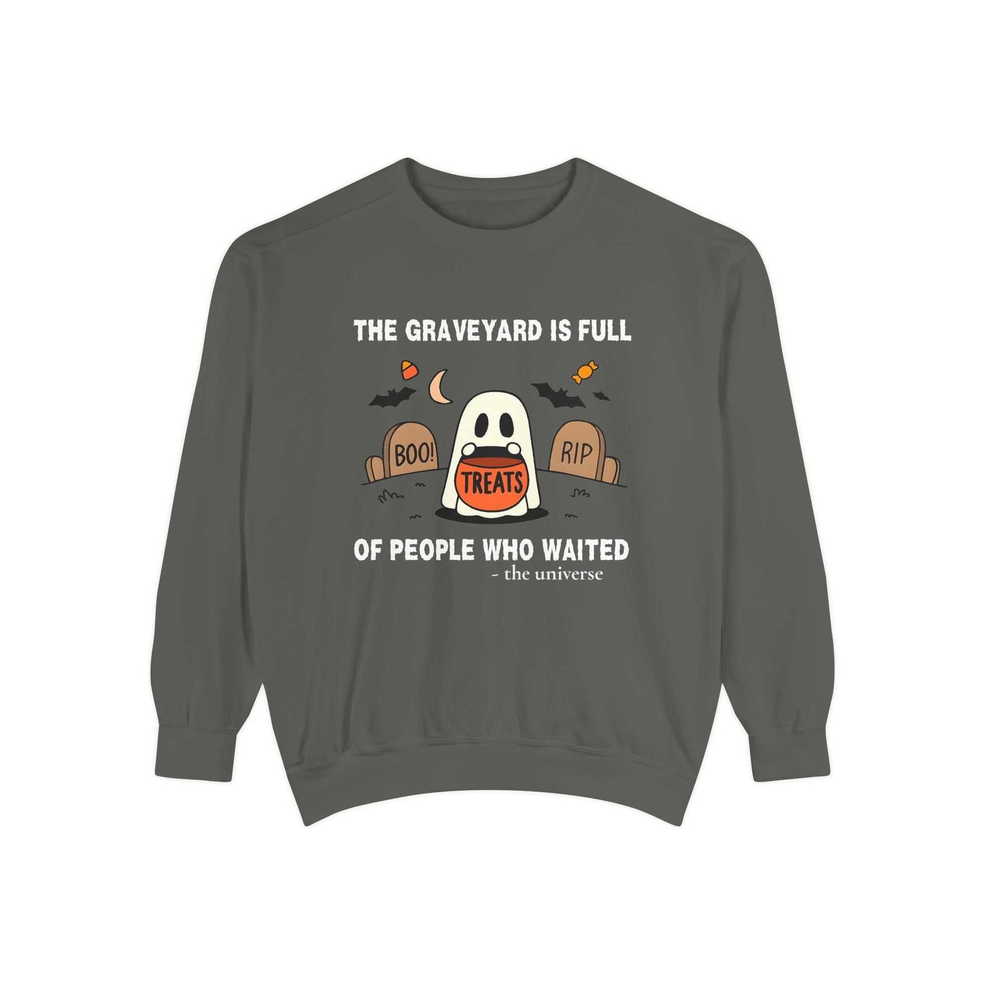 Sweatshirt with a ghost in a graveyard holding a treat bucket.