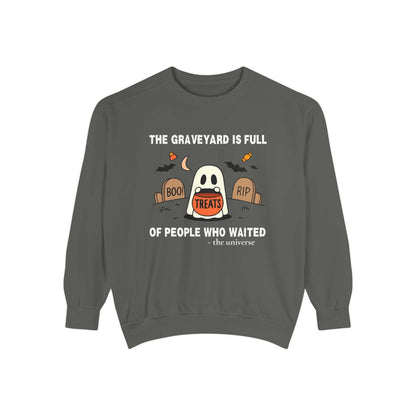 Sweatshirt with a ghost in a graveyard holding a treat bucket.