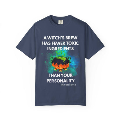 A navy t-shirt with a witch's cauldron design and the text "A witch's brew has fewer toxic ingredients than your personality".