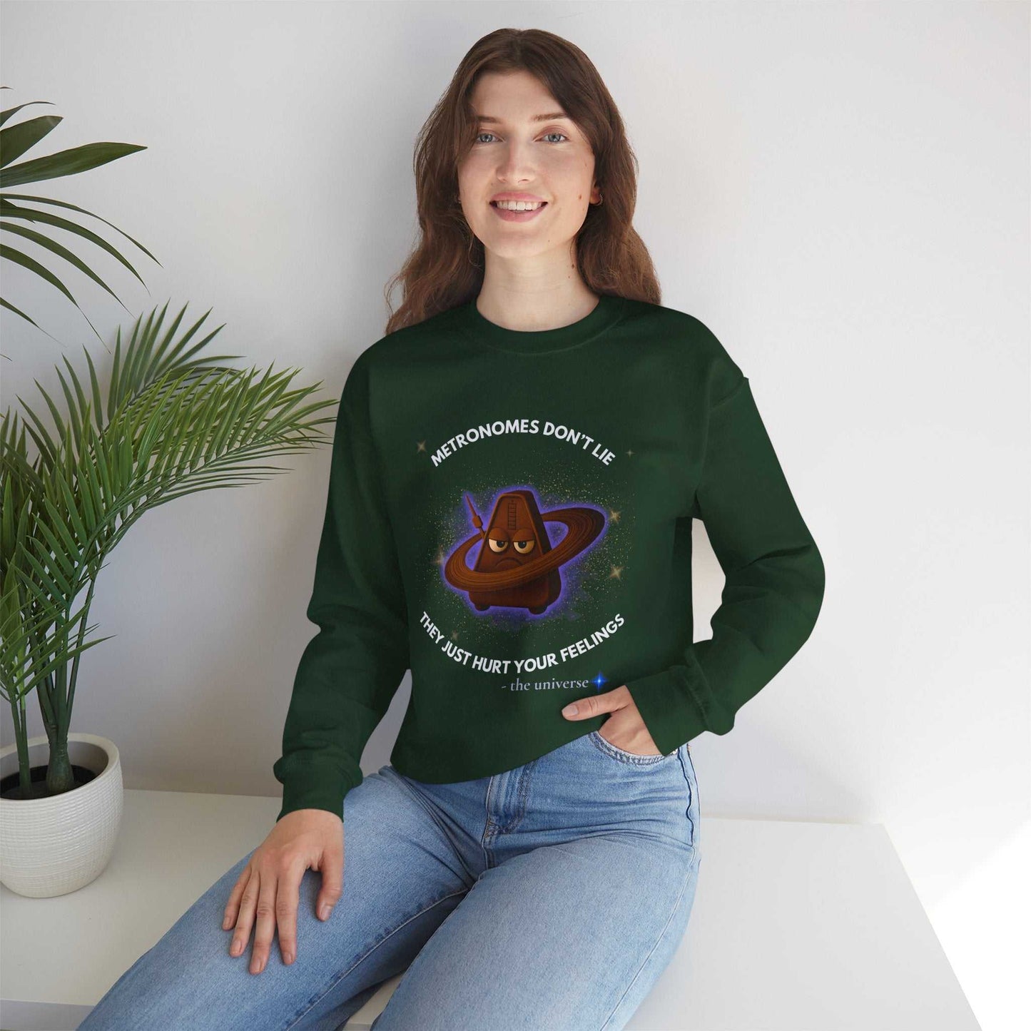 A dark green sweatshirt with a graphic of a grumpy metronome in space.