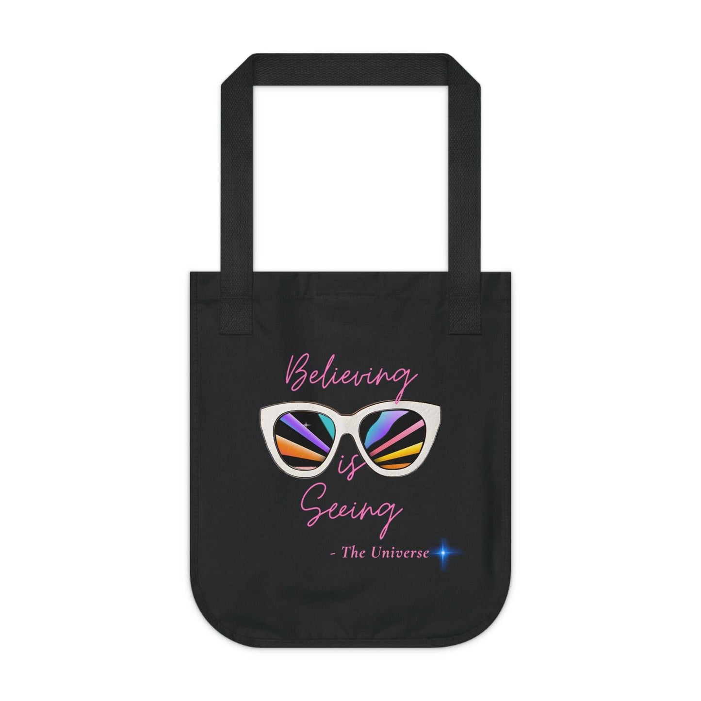 Black organic canvas tote bag with "Believing is Seeing" sunglasses graphic and long handles