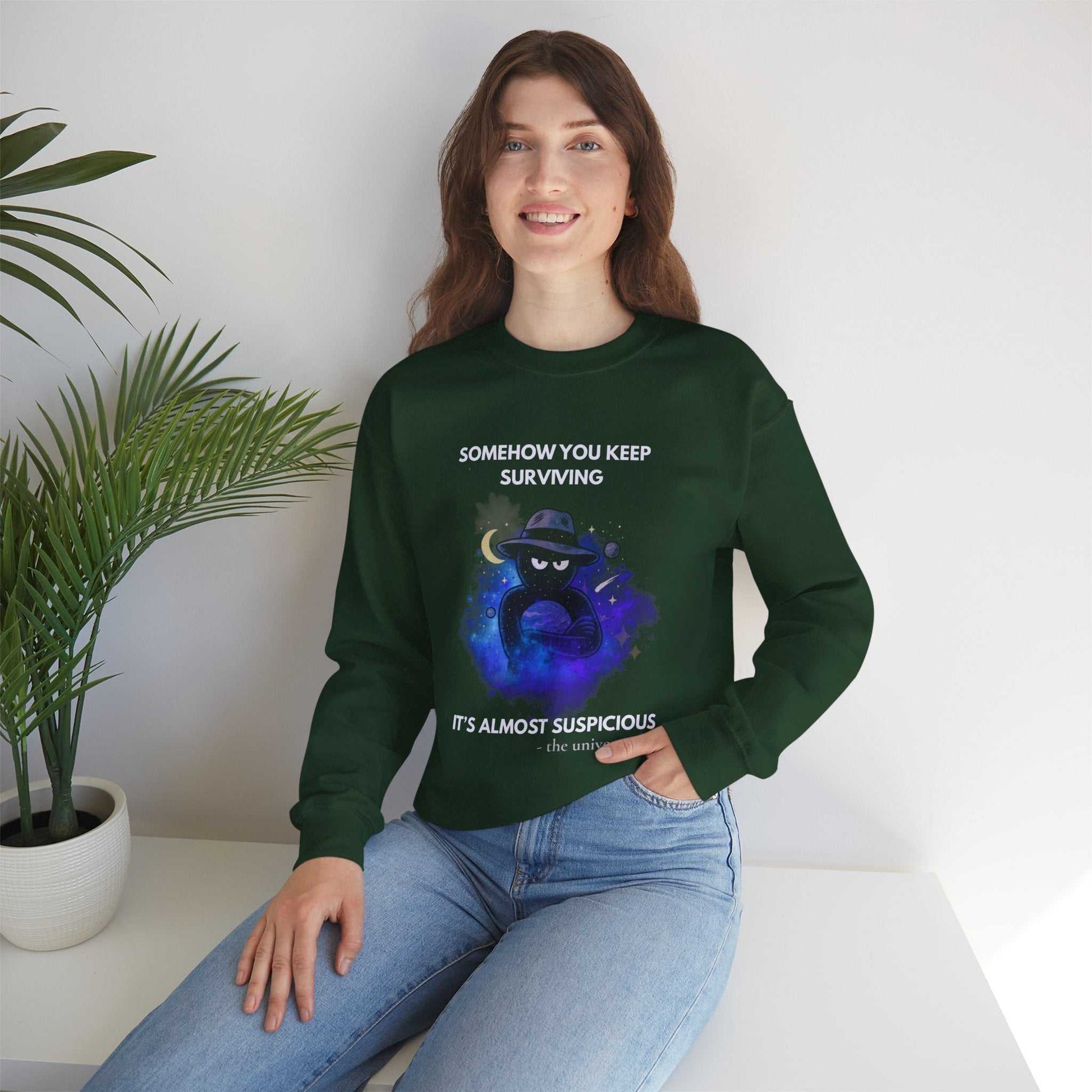 A dark green sweatshirt with a cosmic graphic and text about surviving.