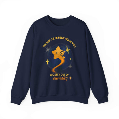A navy sweatshirt with a graphic of a star looking through a magnifying glass and text about curiosity.
