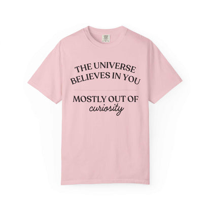 Light pink Comfort Colors graphic tee with black text: The Universe Believes in You, Mostly Out of Curiosity, Youniverses fashion.